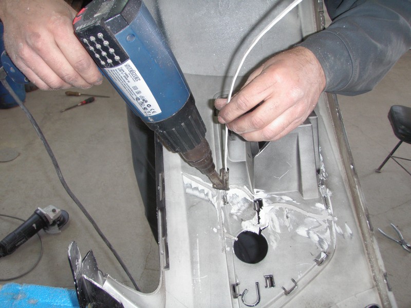 Majstor toplinskim pištoljem vari plastični autodio